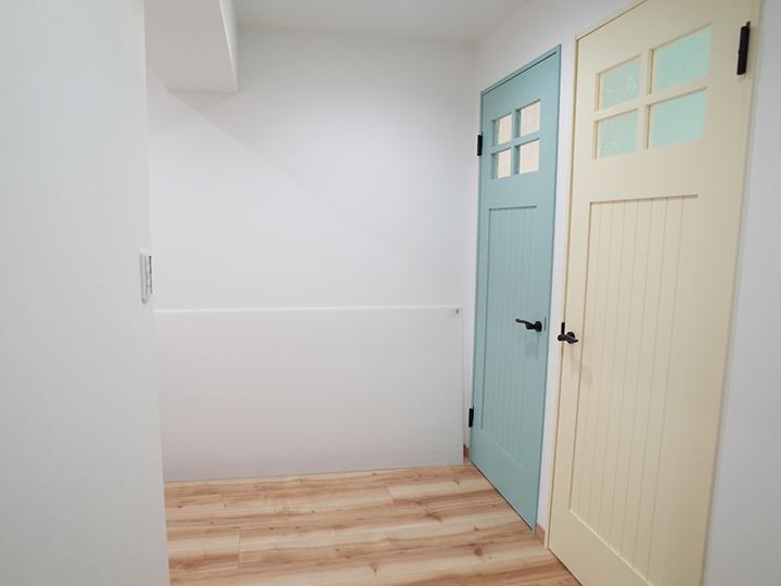 施工後の廊下の様子です。<br />
部屋ごとに色の違うカラーの扉を設置しました。