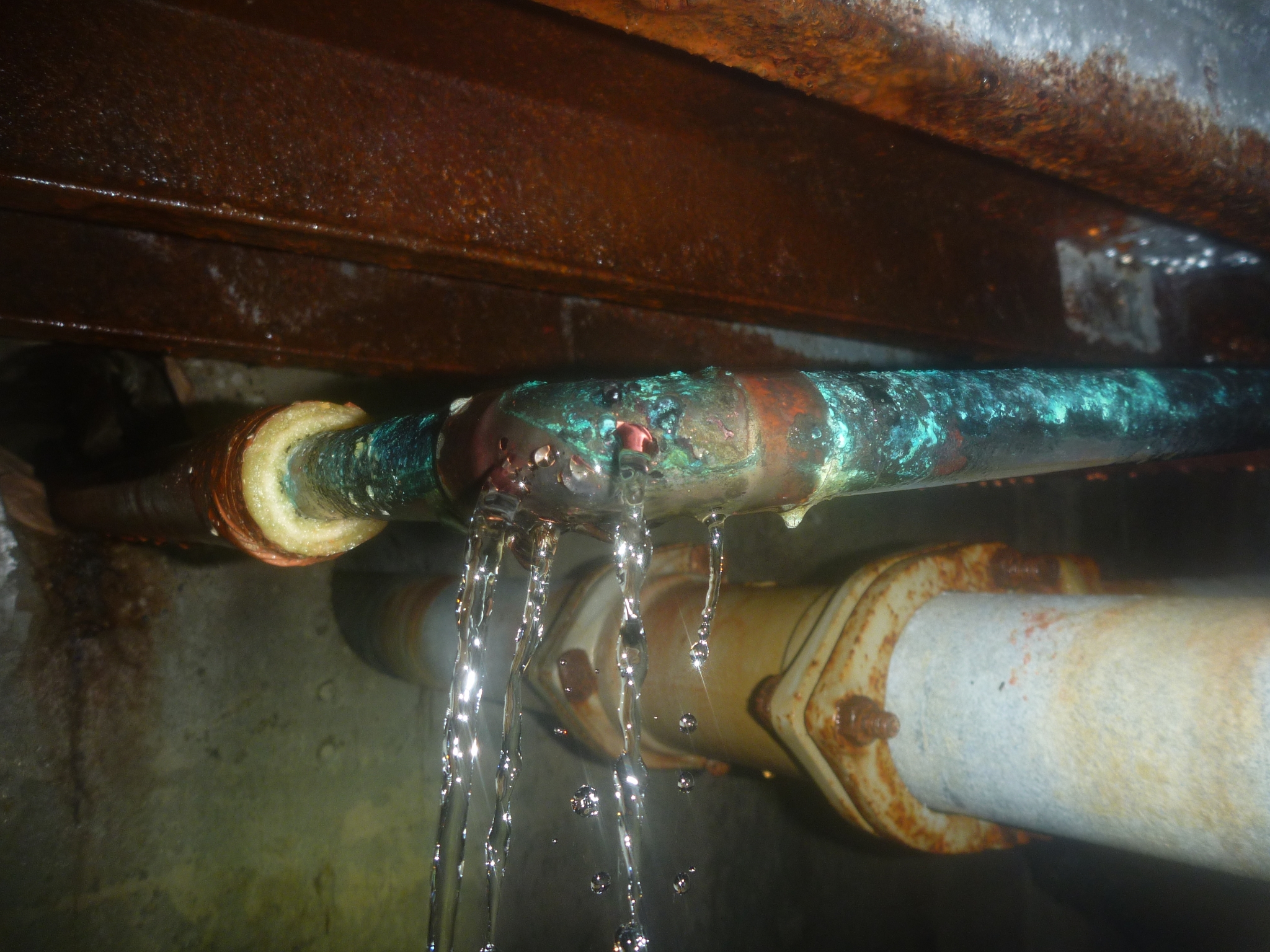床下の給湯管から水が噴き出している様子。